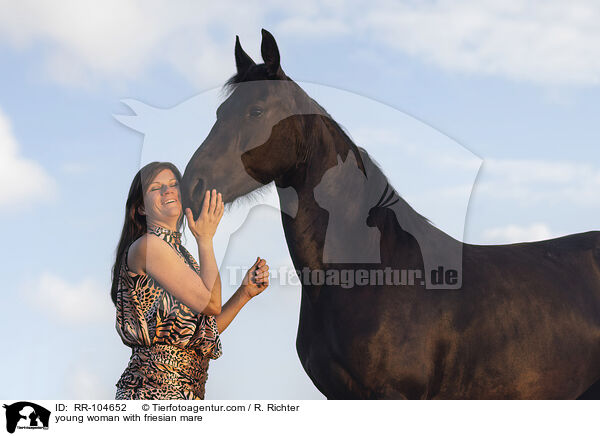 young woman with friesian mare / RR-104652