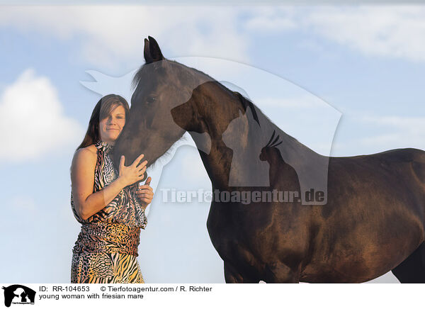 young woman with friesian mare / RR-104653