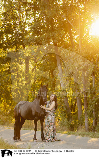 young woman with friesian mare / RR-104691