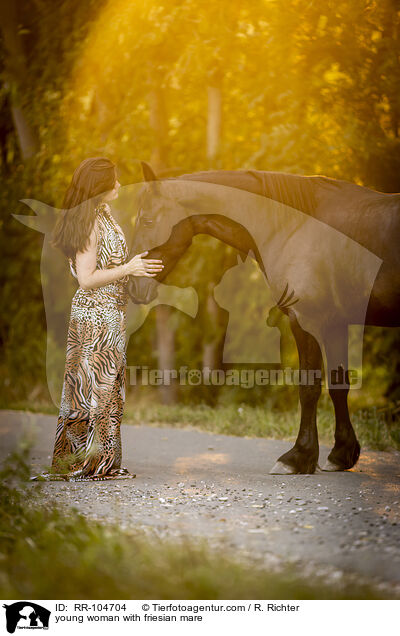 young woman with friesian mare / RR-104704