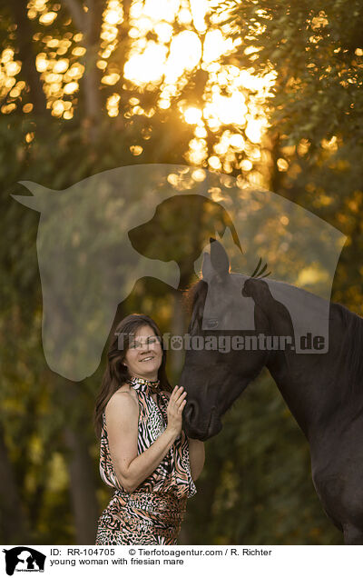 young woman with friesian mare / RR-104705