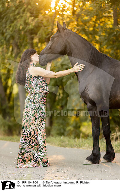 young woman with friesian mare / RR-104706