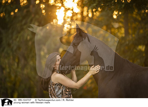 young woman with friesian mare / RR-104707