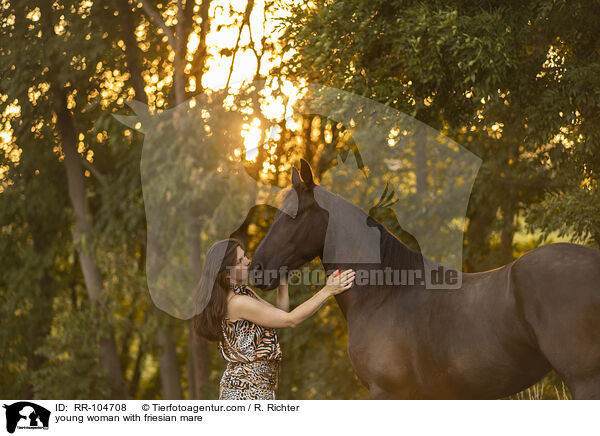 young woman with friesian mare / RR-104708