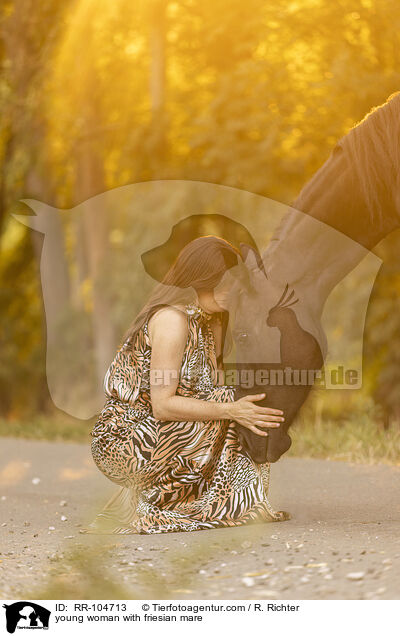 young woman with friesian mare / RR-104713