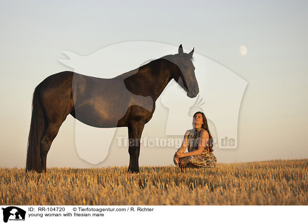 young woman with friesian mare / RR-104720
