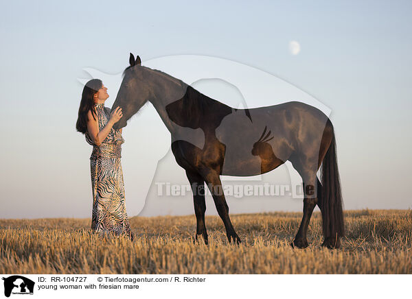 young woman with friesian mare / RR-104727