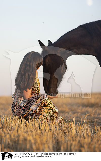 young woman with friesian mare / RR-104728