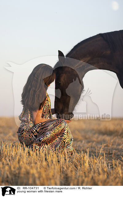 young woman with friesian mare / RR-104731