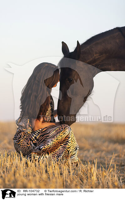 young woman with friesian mare / RR-104732