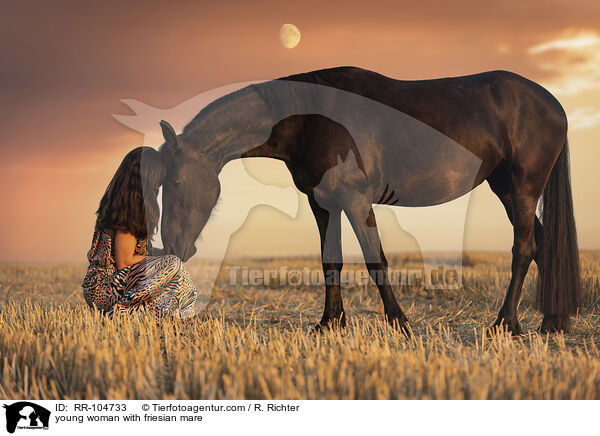 young woman with friesian mare / RR-104733