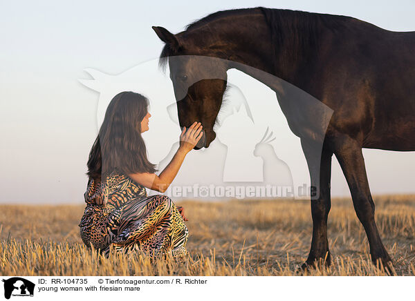 young woman with friesian mare / RR-104735