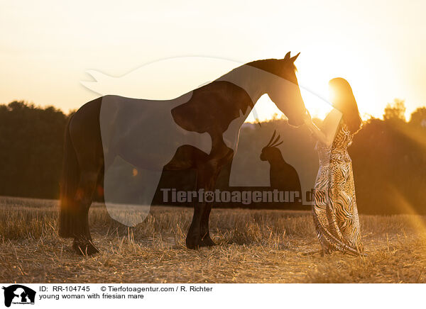 young woman with friesian mare / RR-104745