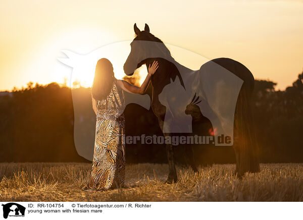 young woman with friesian mare / RR-104754