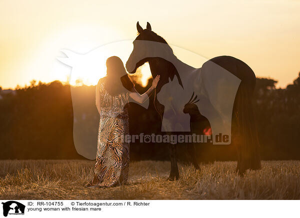 young woman with friesian mare / RR-104755