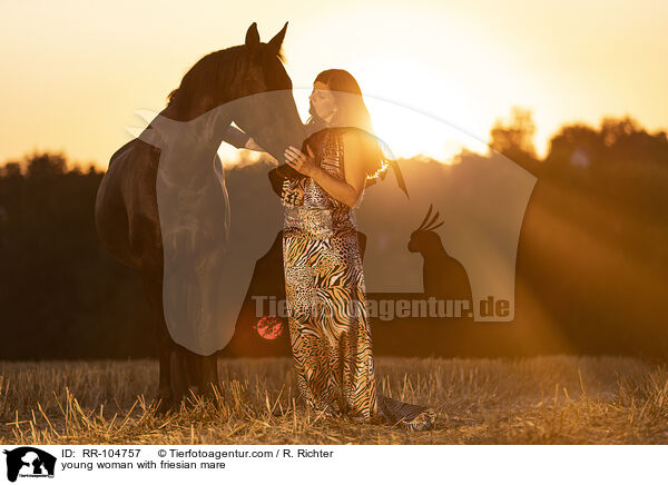 young woman with friesian mare / RR-104757