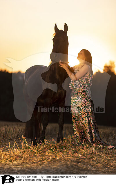 young woman with friesian mare / RR-104758