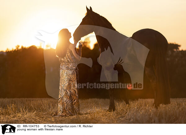 young woman with friesian mare / RR-104753