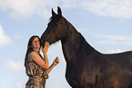 young woman with friesian mare