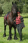 woman with friesian horse at show