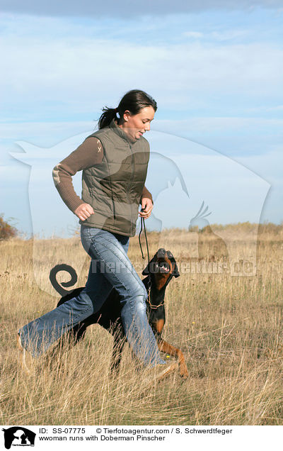 wwoman runs with Doberman Pinscher / SS-07775