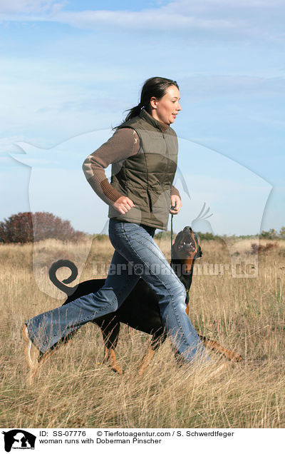 woman runs with Doberman Pinscher / SS-07776